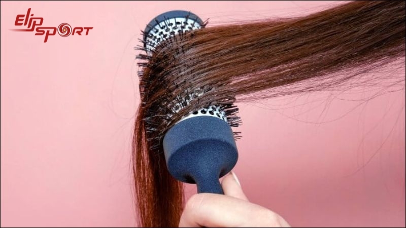 Đặt đu&ocirc;i t&oacute;c cụp v&agrave;o th&acirc;n lược đầu tr&ograve;n để chuẩn bị sấy